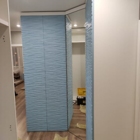 распашной угловой шкаф с фрезерованными в виде волны фасадами и зеркалом.